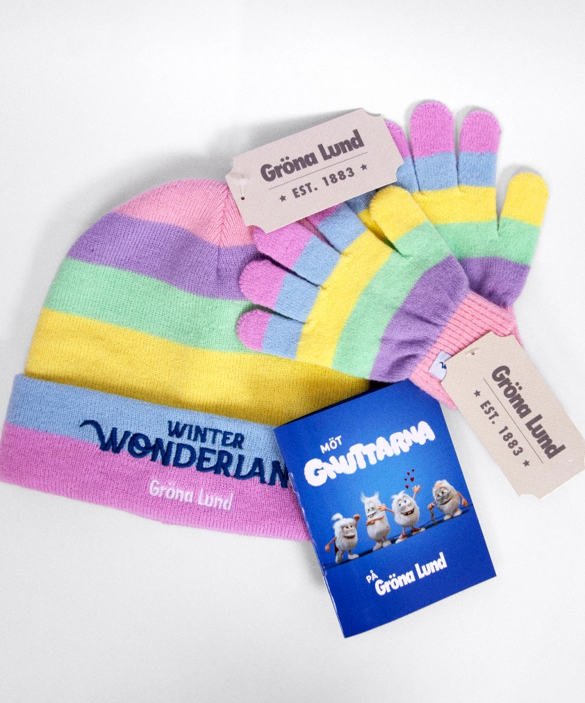 En metallf&auml;rgad Vasa &ouml;rlogsskepp-nyckelring och en rund Vasa 1628-magnet med bl&aring; emalj, utlagda p&aring; ett tr&auml;underlag